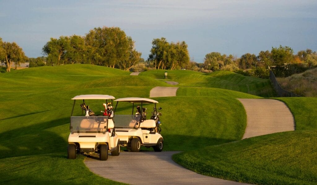 Two Golf Carts Moving on a Golf Path