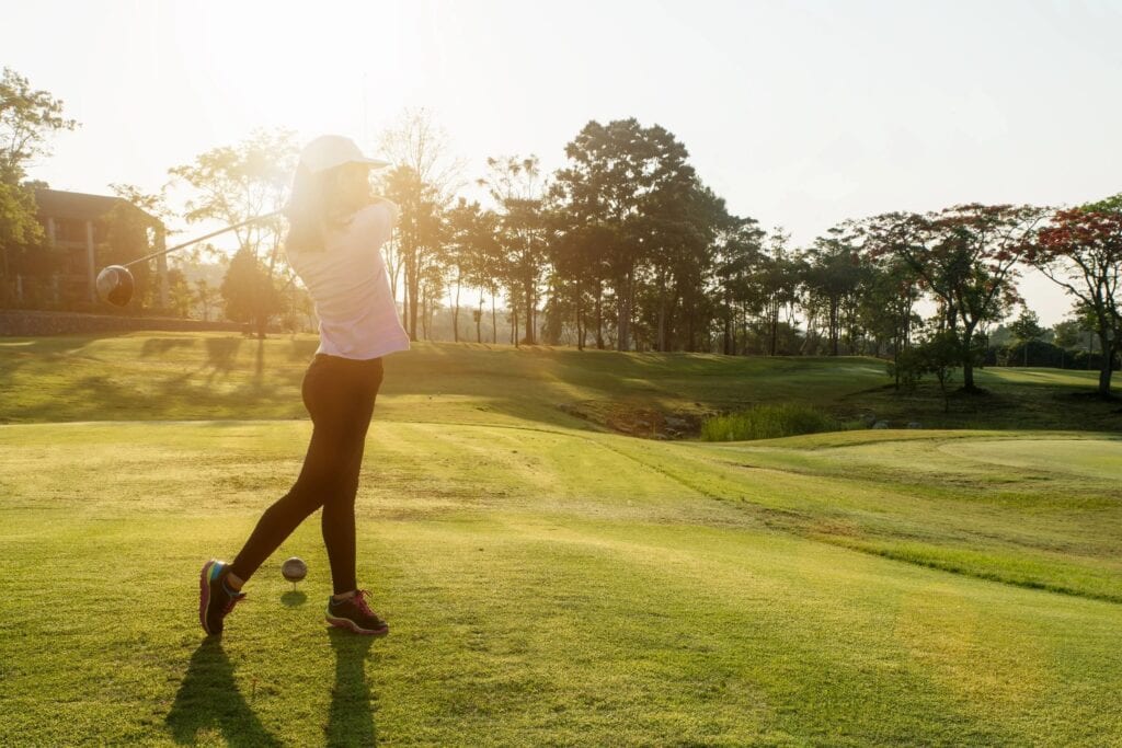 A Woman Standing on a Golf Course Field